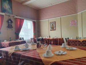 a room with tables with plates and bowls on them at Hostal Papo in Osorno
