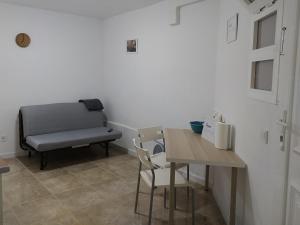 een kamer met een tafel, een stoel en een bank bij Seagull Estudios in Pozo Izquierdo