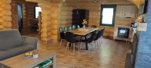 a kitchen and dining room with a table and chairs at Wild tree house in Vărşag