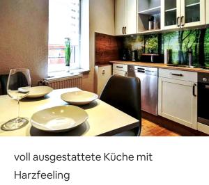 - une cuisine avec une table et un verre de vin dans l'établissement Apartment Harzduft zentrumnah GrillChill Garten, à Thale