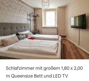 - une chambre avec 2 lits jumeaux et une télévision dans l'établissement Apartment Harzduft zentrumnah GrillChill Garten, à Thale