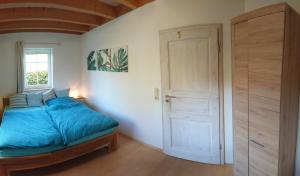 1 dormitorio con cama, ventana y puerta en Privatzimmer im Schwedenhaus Unsere Kleine Farm, en Monschau