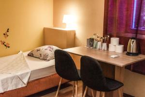 a small room with a bed and a table with two chairs at Hostel Martin in Koper