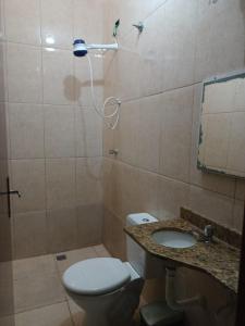 a bathroom with a toilet and a sink and a shower at Lindo Sobrado in Mongaguá