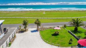 uma vista aérea de um parque com palmeiras e do oceano em Carters Beach Seaside Accommodation em Carters Beach