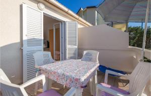 a table and chairs on a balcony with an umbrella at Nice Apartment In Stara Novalja With House Sea View in Stara Novalja