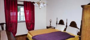 a bedroom with a bed with red curtains and a window at AFIFE "Porta da Alegria" in Viana do Castelo