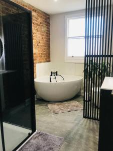 uma banheira na casa de banho com uma janela em Stunning Super King, Close to Beach, Shared Bathroom em St. Leonards