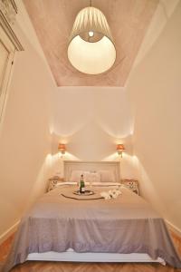 a bedroom with a white bed with a ceiling at Nadi's Home – Heart of Budapest in Budapest