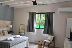 Schlafzimmer mit einem Bett und einem Fenster in der Unterkunft cabañas La Amelia Premium con piscina privada 2 personas in Mina Clavero