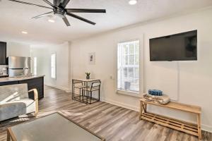 a living room with a ceiling fan and a tv at Chic Cottage Retreat with Grill, 2 Mi to MSU! in Starkville