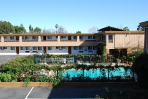 um edifício com piscina em frente a um parque de estacionamento em Stanford Motor Inn em Palo Alto