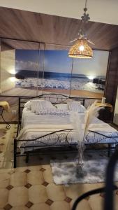 um quarto com uma cama com uma pintura do oceano em the lighthouse accommodation em Taranto