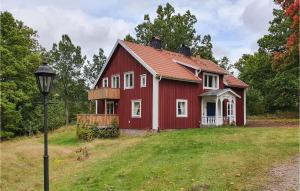 una casa roja en una colina con luz de la calle en Beautiful Home In lmhult With Kitchen, en Älmhult