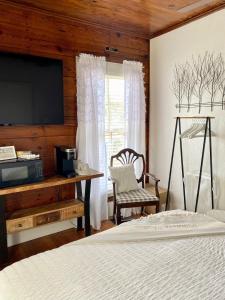 a bedroom with a bed and a desk and a television at Pennoli Bed and Breakfast in Gatesville