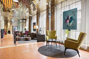 a lobby with chairs and a table in a building at Best Western Hotel Svava in Uppsala