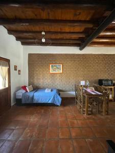 um quarto com uma cama e uma mesa num quarto em Pasillos del Viñedo em Cafayate