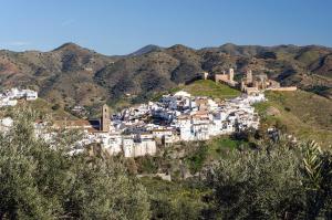a village on a hill with mountains in the background at Alojamiento Alcantara in Alora