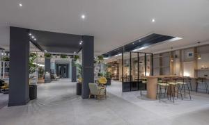 un hall avec des tables et des chaises dans un bâtiment dans l'établissement Radisson Blu Hotel Dublin Airport, à Cloghran