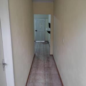 um corredor vazio com um quarto com uma porta e um piso em Pousada Casa Valério em Pelotas