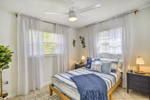 a bedroom with a bed with blue pillows and a window at Merritt Island Home Fire Pit and Canal Access! in Merritt Island