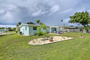 a house with a yard with trees in front of it at Merritt Island Home Fire Pit and Canal Access! in Merritt Island