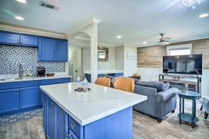 uma cozinha e sala de estar com armários azuis e um sofá em Blue Cottage in the Bayou with Private Yard! em Baton Rouge
