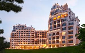 a large white building with two tall buildings at Cabacum Beach Private Apartaments in Golden Sands