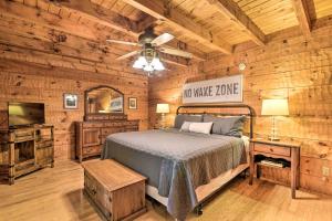 1 dormitorio en una cabaña de madera con 1 cama y TV en Serene Lewisburg Lakefront Retreat with Dock, en Lewisburg