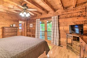 Un dormitorio con una cama y un televisor de pantalla plana. en Serene Lewisburg Lakefront Retreat with Dock, en Lewisburg