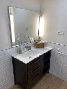 baño con lavabo y espejo grande en Bluu House, en Llanes