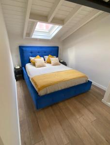 Cama azul en habitación con ventana en Bluu House, en Llanes