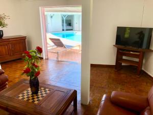 a living room with a vase of flowers on a chess board at Villa le Moulin - Didier BERVILLE in Le Gosier