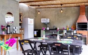 een keuken met een tafel met stoelen en een koelkast bij Suítes Las Flores Maresias in Maresias