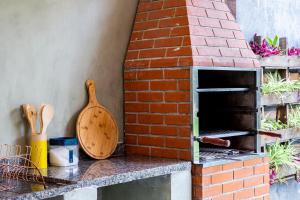 a brick oven sitting on top of a counter at Suítes Las Flores Maresias in Maresias