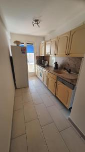 una cucina con frigorifero e pavimento piastrellato di Appartement Spacieux Proche Mer a Antibes