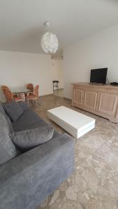 un soggiorno con divano e tavolo di Appartement Spacieux Proche Mer a Antibes