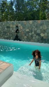 a young girl in the water in a swimming pool at Pasillos del Viñedo in Cafayate