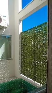 um quarto com uma janela com uma parede verde em Pousada Barbosa em Aparecida