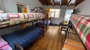 Pokój z 3 łóżkami piętrowymi i ławką w obiekcie Hostal La Guayunga RoofTop w mieście Quito
