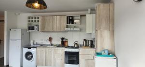 a kitchen with wooden cabinets and a washer and dryer at PEY KAU in Ushuaia