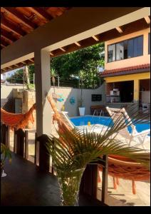un jarrón en una mesa con sillas y una piscina en Lindo Sobrado Amarelo -próximo a praia, en Mongaguá
