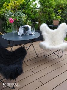 eine Terrasse mit zwei weißen Stühlen und einem Tisch in der Unterkunft Suite dans Une Echoppe in Bègles