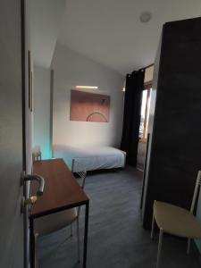 una camera con letto e tavolo e una stanza con sedia di Airport Boulevard Guesthouse a Grassobbio