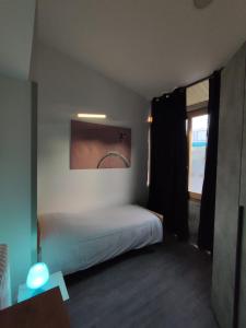 una piccola camera con letto e finestra di Airport Boulevard Guesthouse a Grassobbio