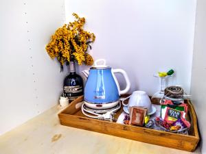 uma bandeja com um bule de chá e um vaso de flores em Guest House Lorvand em Roma