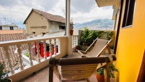 a balcony with a chair and a view of a house at Hostal La Guayunga RoofTop in Quito