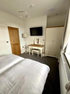 Un dormitorio con una cama y un escritorio con televisión. en Apt D in Old Grade 2 Converted Farmhouse, en Market Weighton