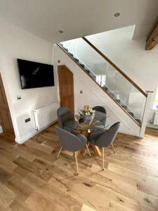 a dining room with a table and chairs and a staircase at Apt D in Old Grade 2 Converted Farmhouse in Market Weighton