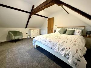 a bedroom with a large bed and a chair at Apt D in Old Grade 2 Converted Farmhouse in Market Weighton
